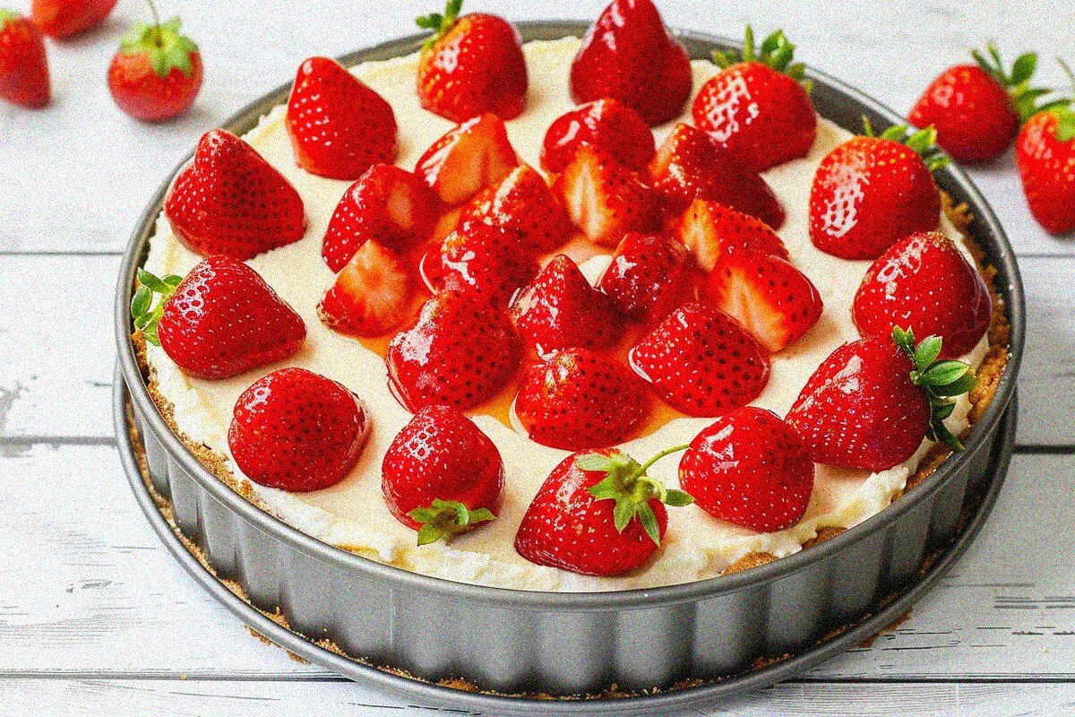 Whole strawberry cheese cake in springform pan with fresh strawberry garnish, ready to serve